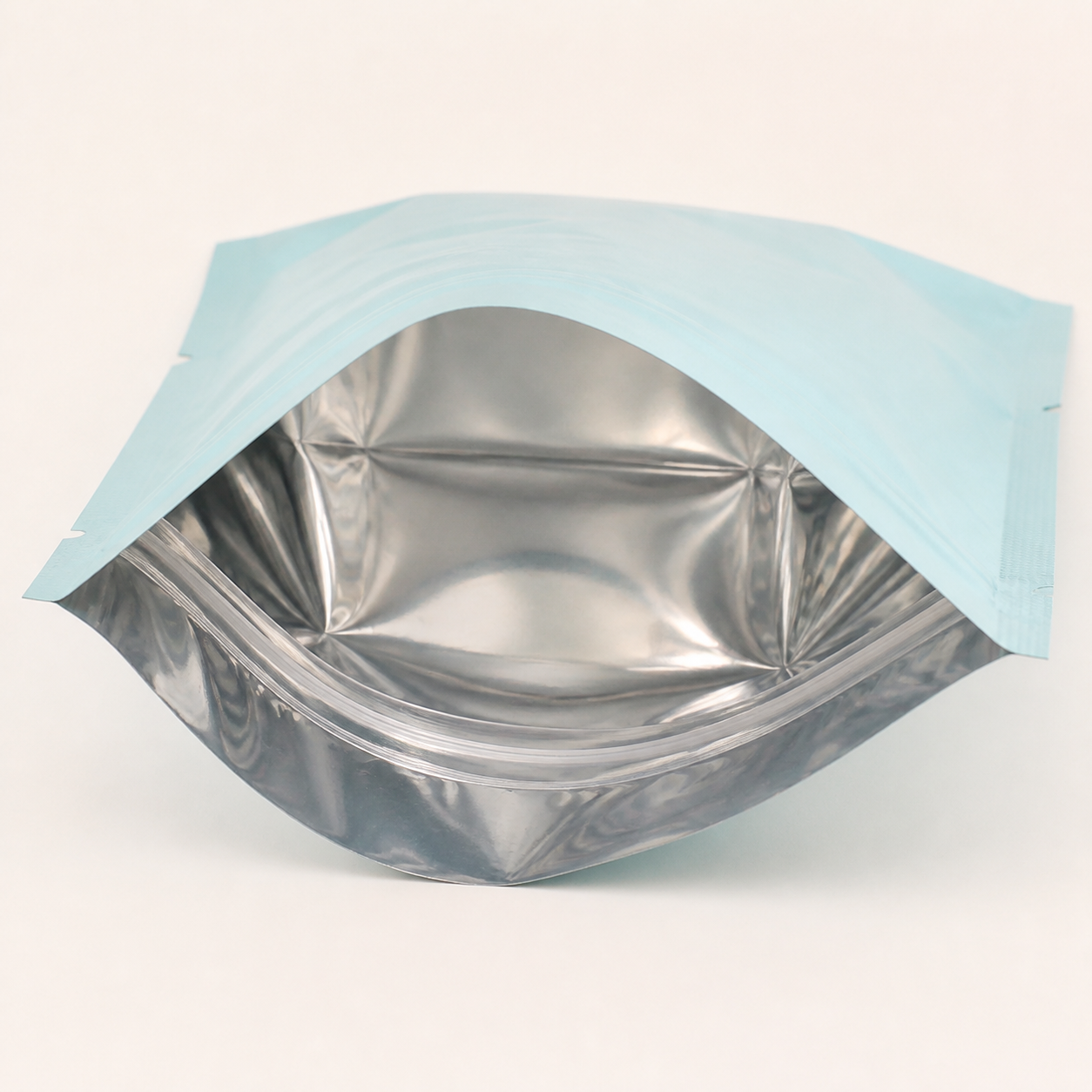 Open aqua pouch showing its reflective aluminum lining